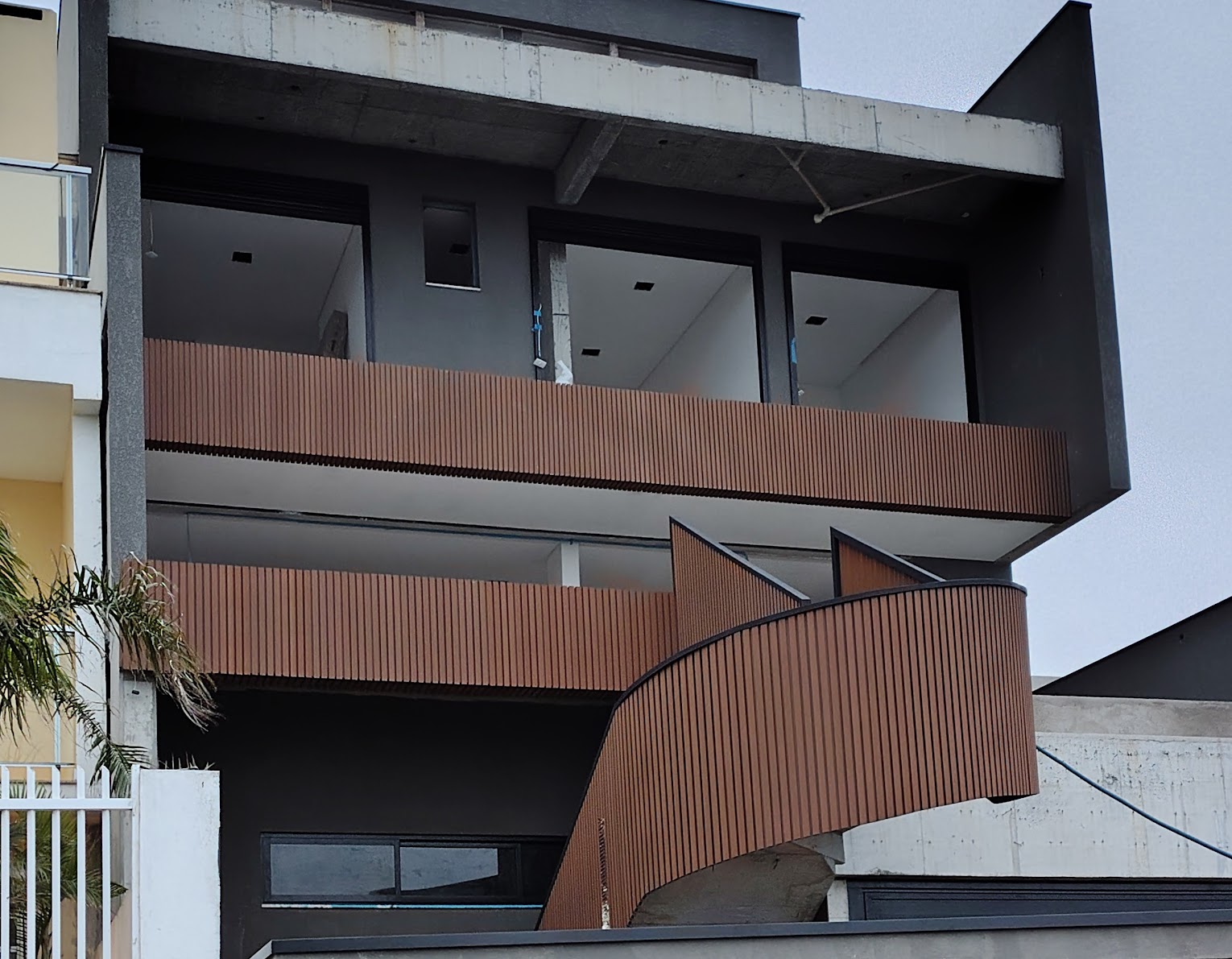 Fachada com ripado curvo em acabamento amadeirado